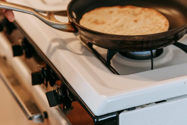 pan with flatbread placed on stove in kitchen